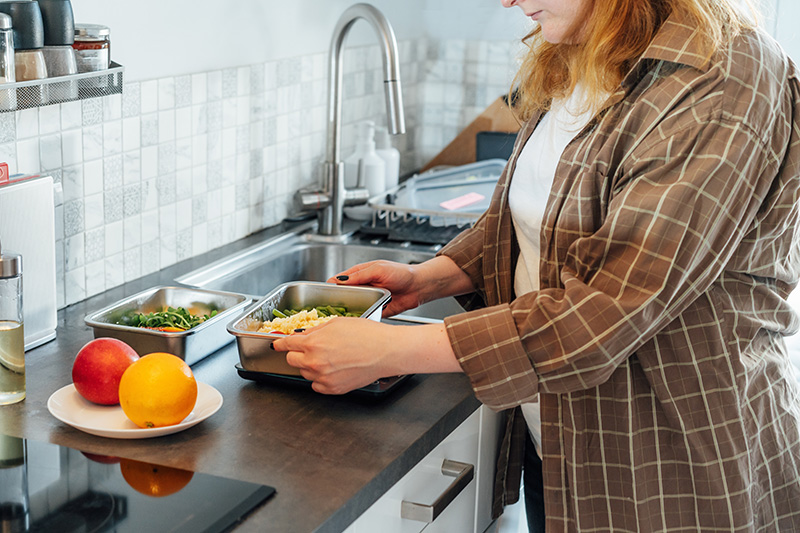 woman weighing food on a scale